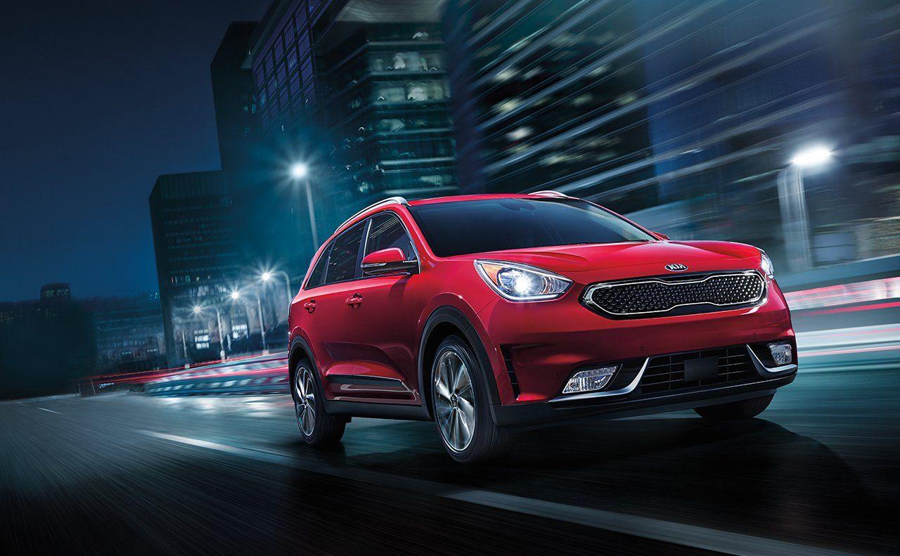 Kia Niro EV red color night on road in city lights background
