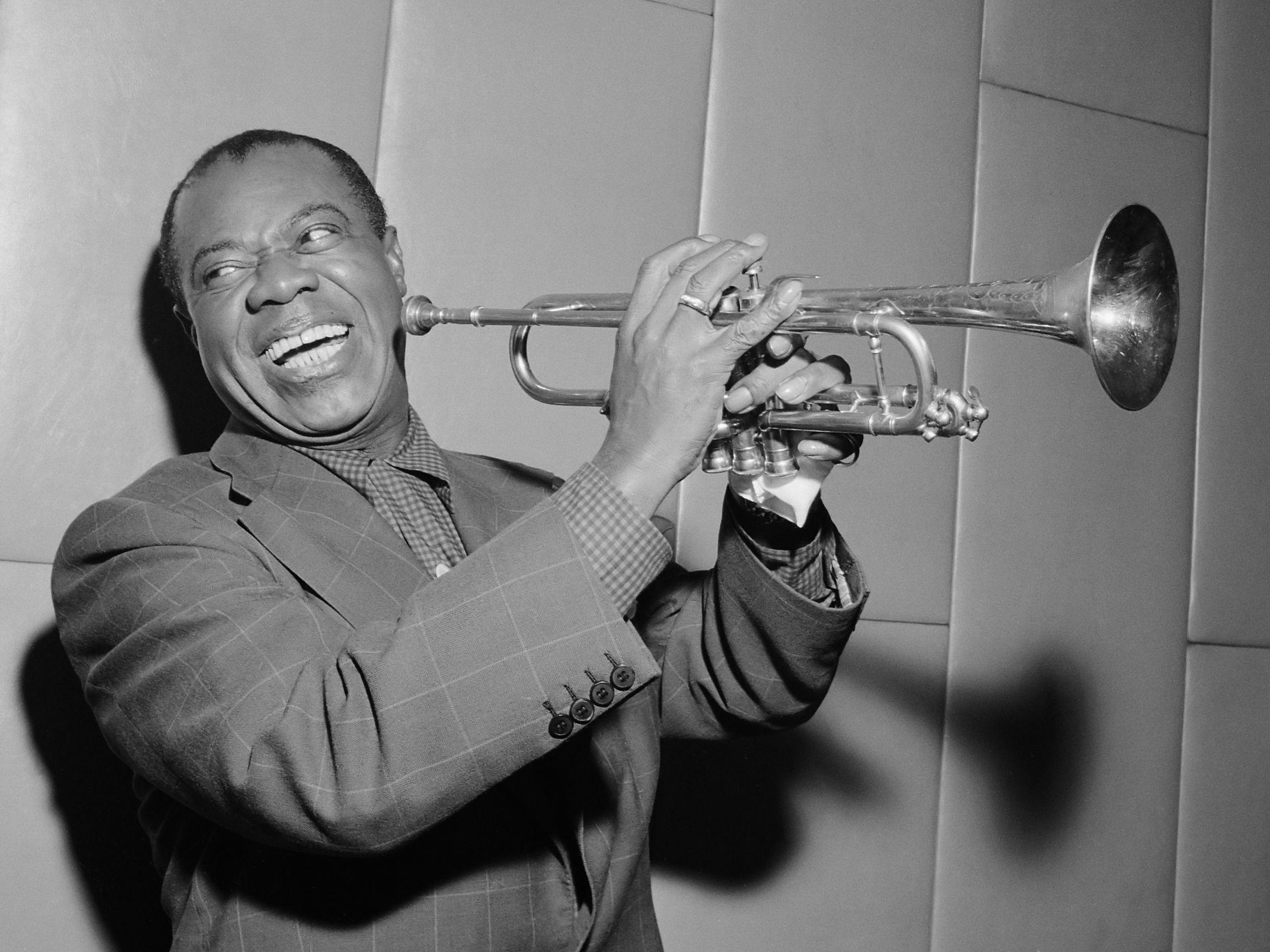 Louis laughing and playing his trumpet in 1955. Satchmo