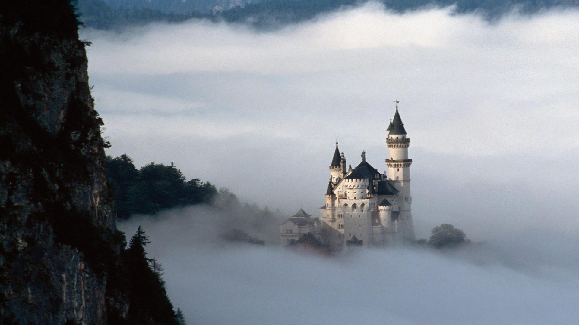 Neuschwanstein castle Bavaria Germany clouds mist around castle
