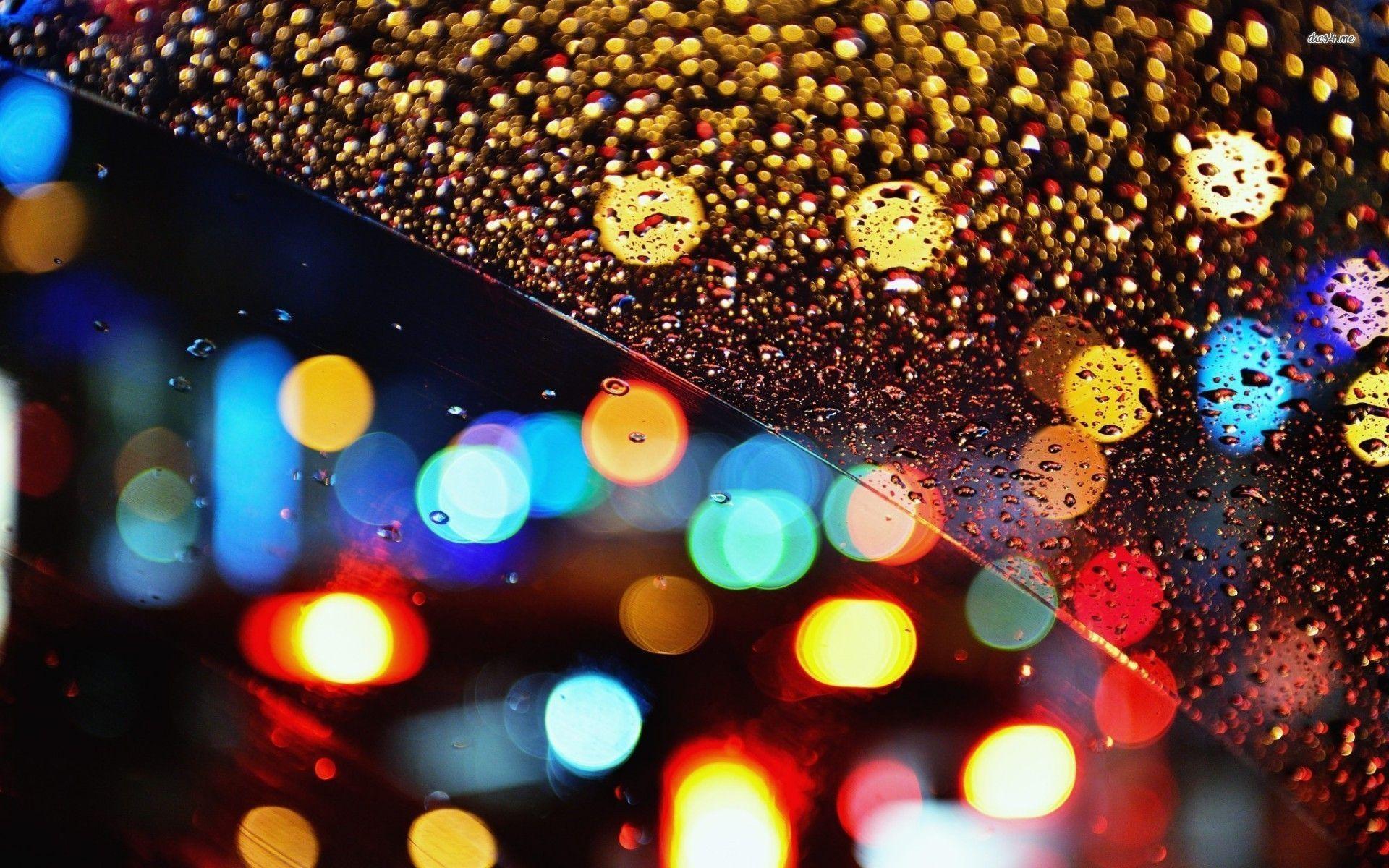 Multicolored lights behind the rainy window wallpaper