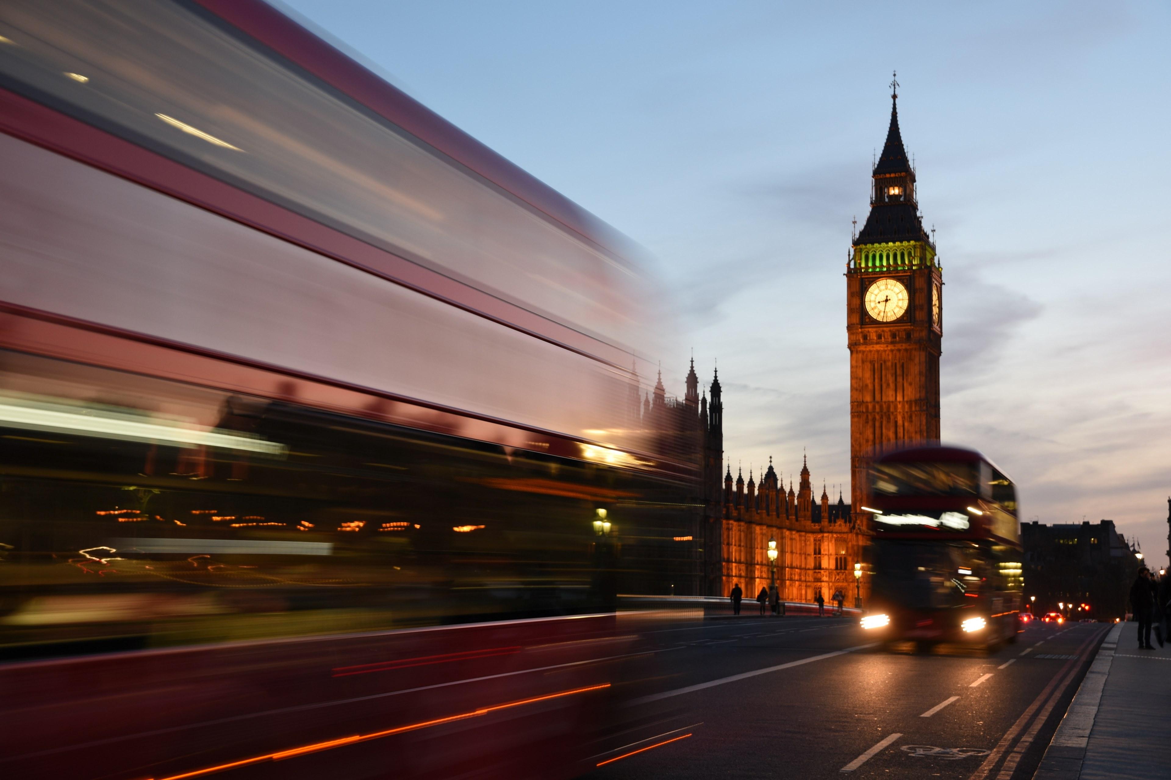 a long exposure shot of double decker buses near the houses