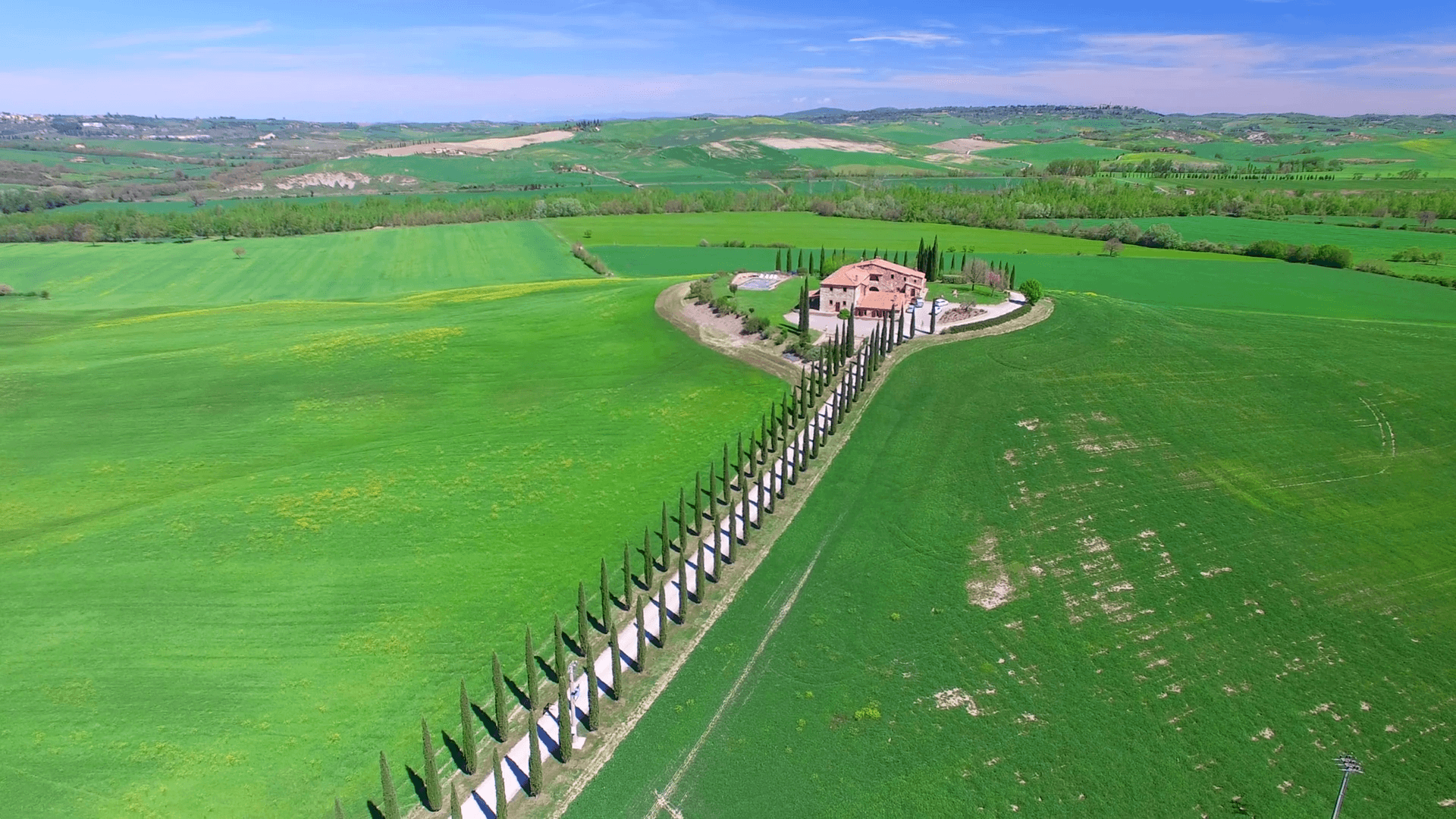 Aerial view of Tuscany countryside with cypresses and old house