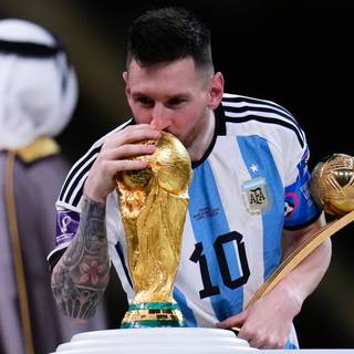 Lionel Messi Kissing the World Cup trophy wallpaper