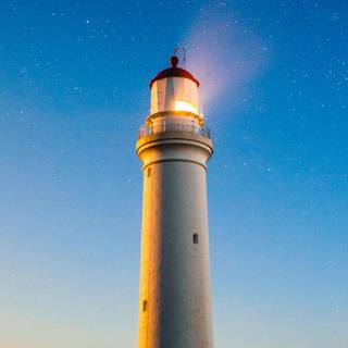 Lighthouse guiding boat wallpaper