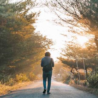 Alone boy walking on road wallpaper