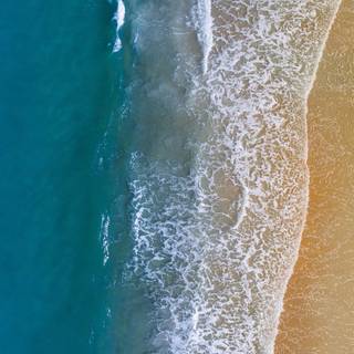 Aerial view beach sand and ocean waves wallpaper