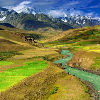 Mountain stream down to a valley of fields
