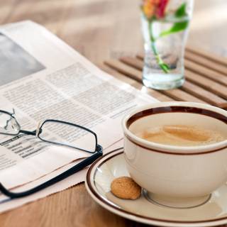 White cup of the coffee and fresh flowers