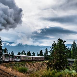 train machine smoke trees clouds bridge railway mountain