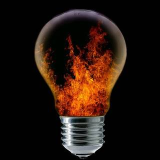 Light bulb with fire on the black