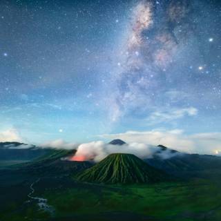 Munte verde sub cer albastru cu stele în timpul nopții