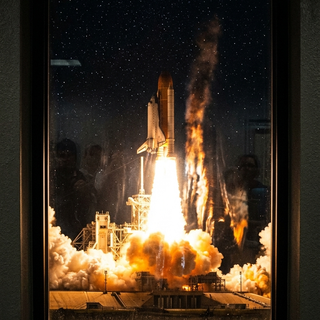 Window View of a Space Shuttle launch at Night