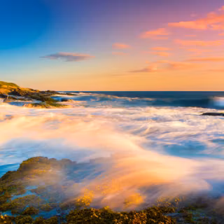 Lighthouse on a rugged coast at sunset