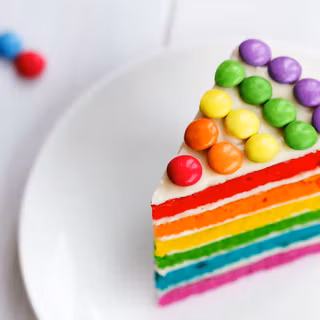 Colorful slice of rainbow layer cake