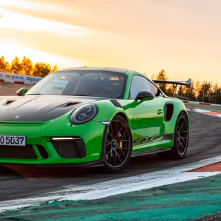 Porsche 911 GT3 RS parked on the track by a sunset