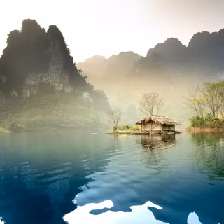 A small hut on a small island in the middle of a lake 