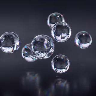 Iridescent Glass Orbs - A minimalist 3D render featuring floating liquid glass spheres with subtle prismatic refractions and reflections, set against a dark gunmetal backdrop.