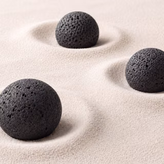 Minimalist Black Lava Stones in Fine Sand