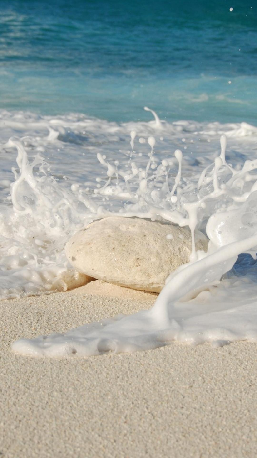 White stone hit by the ocean waves on the beach
