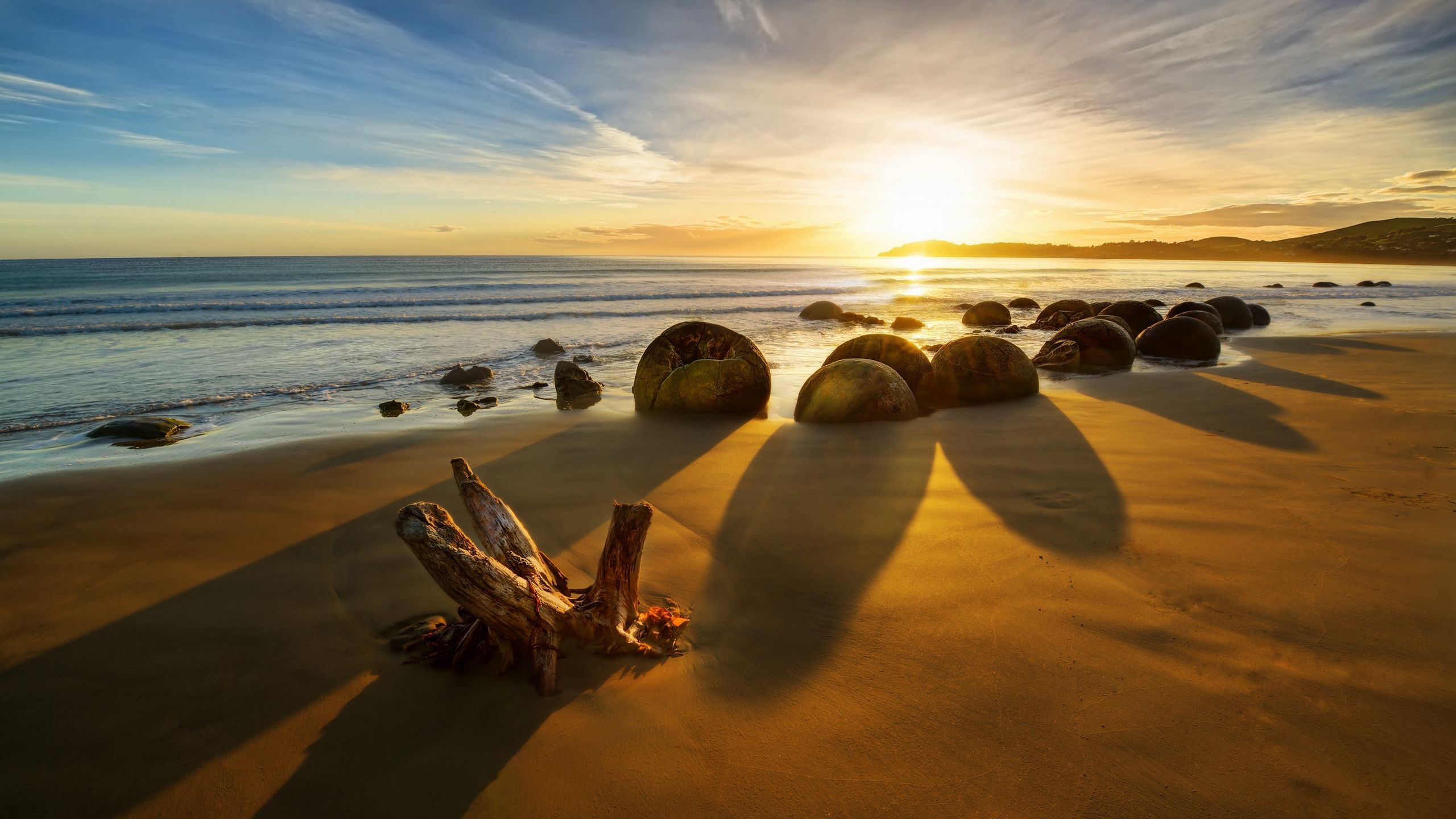 Download wallpaper 2560x1440 new zealand, ocean, sunrise, rocks, coastline widescreen 16:9 HD background
