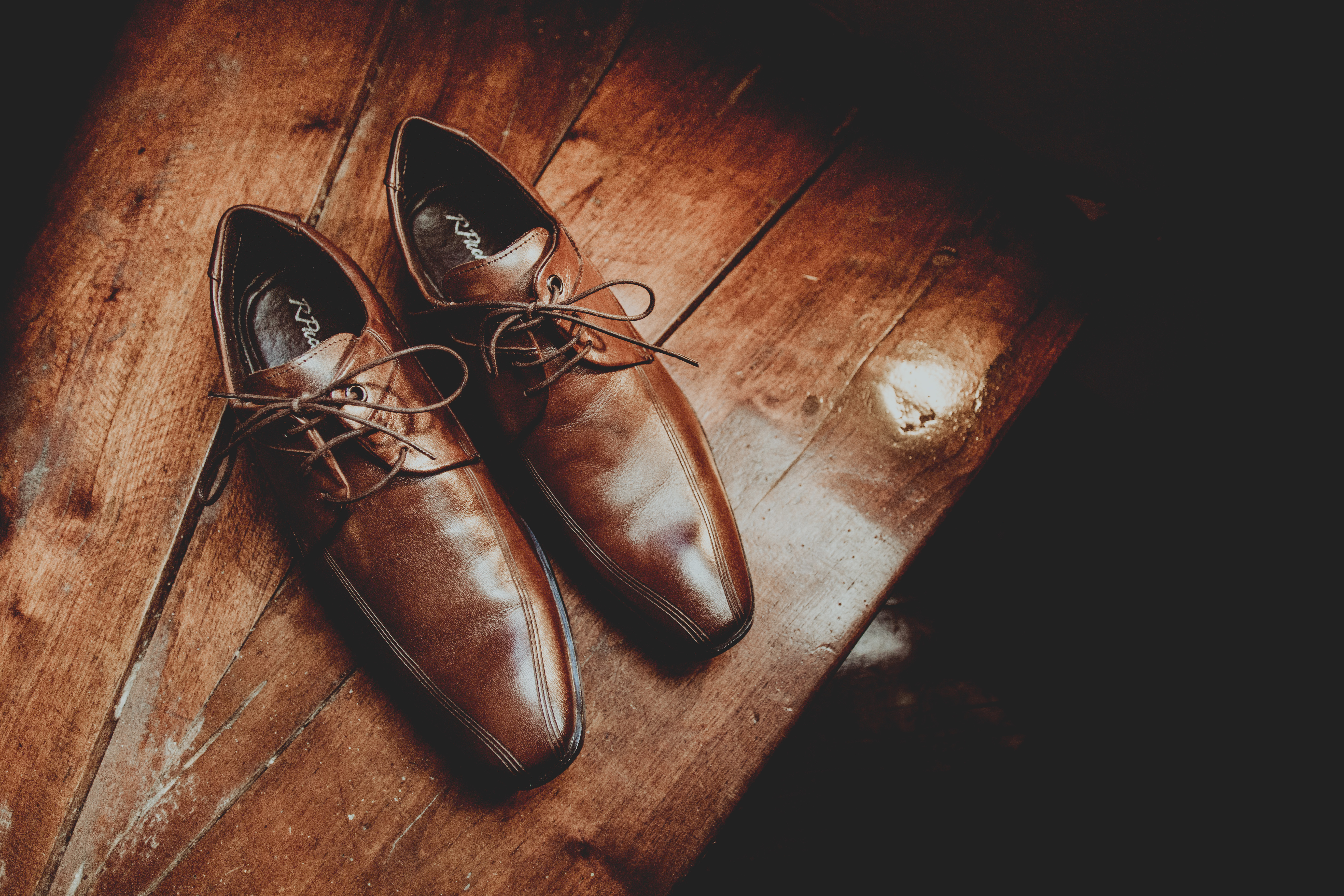 Elegant brown leather shoes on wooden surface · Free