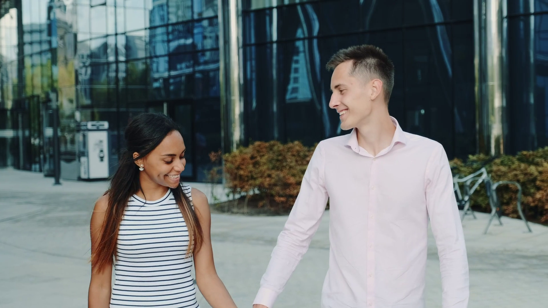 Smiling black girl having a date with her boyfriend in the city center. They holding hands, walking and talking to each other. Stock Video Footage