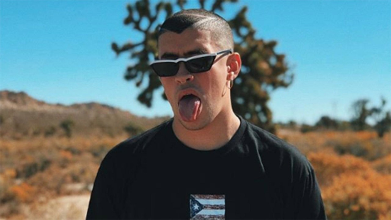 Bad Bunny Aesthetic Is Wearing Black Tshirt Standing In Blur Background With Tongue Out HD Music Wallpaper