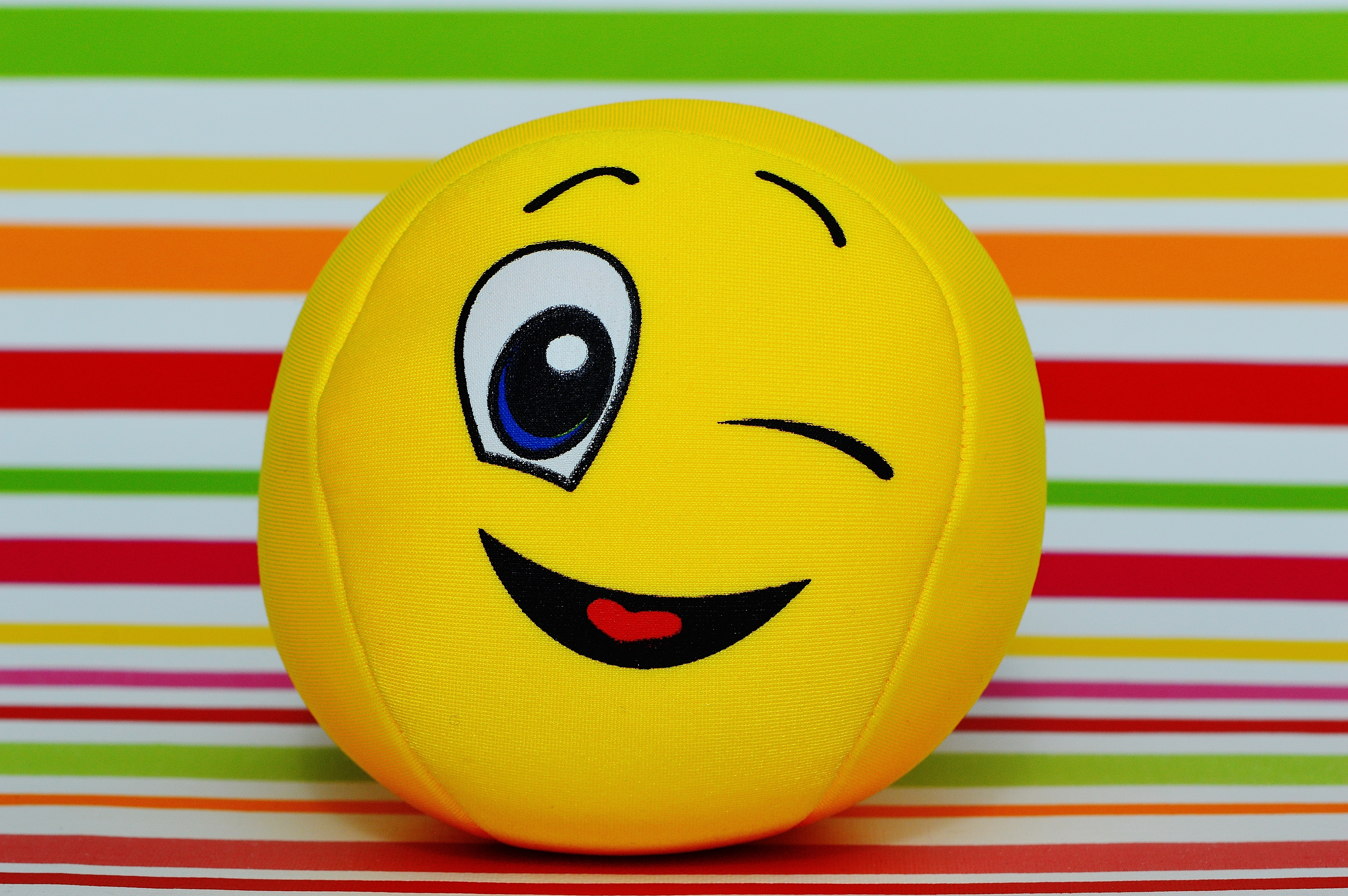 Free download winking smiley ball plush toy on concrete pavement image Peak...