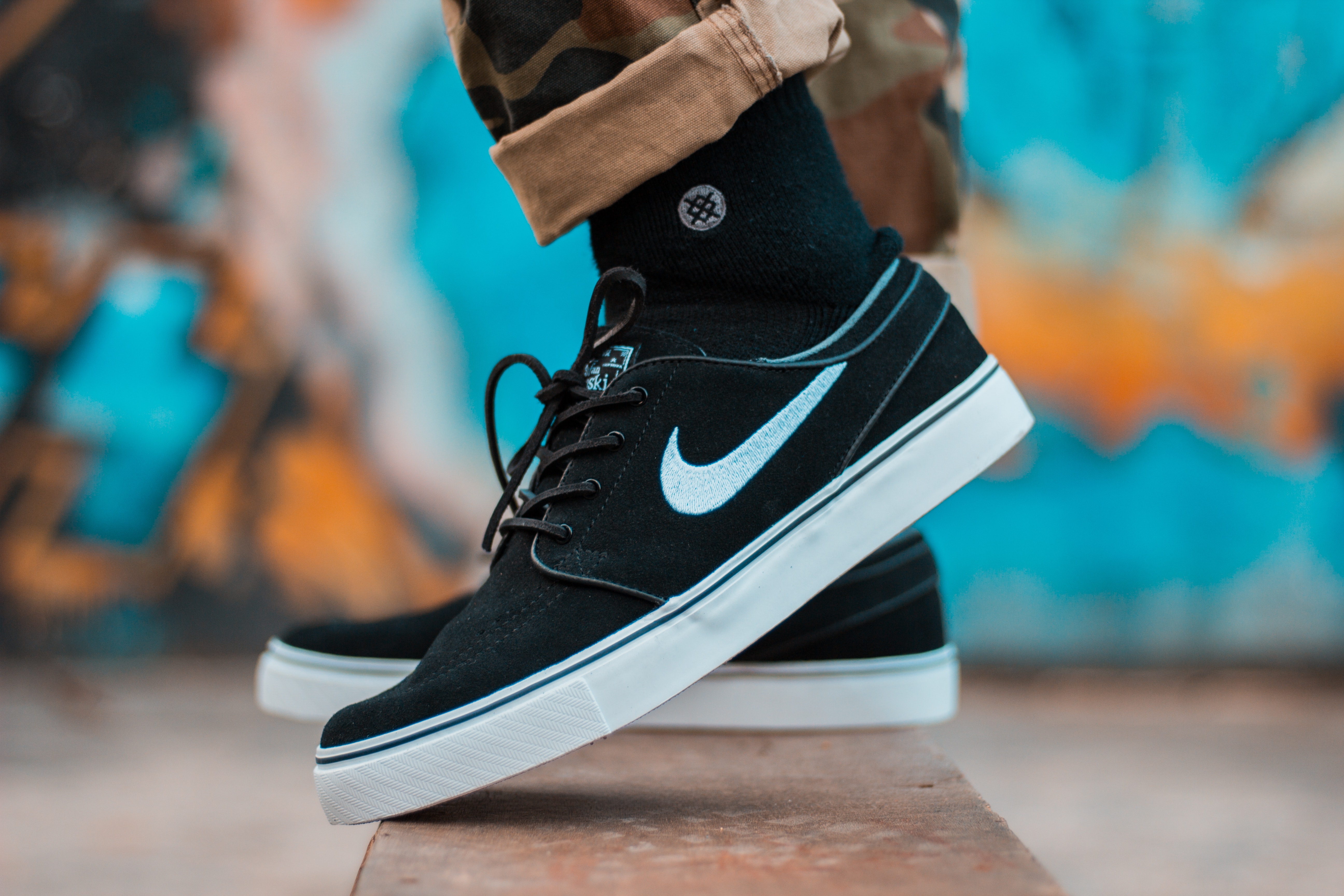 Person in Brown Camouflage Pants and Black Nike Sb Stefan Janoski With Black Socks · Free