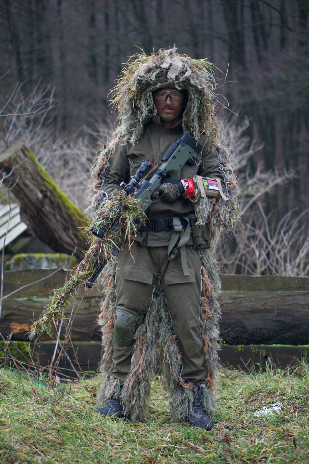 soldier covered with grass holding sniper rifle photo