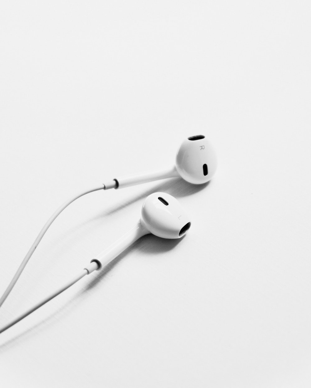 apple earpods on white surface photo