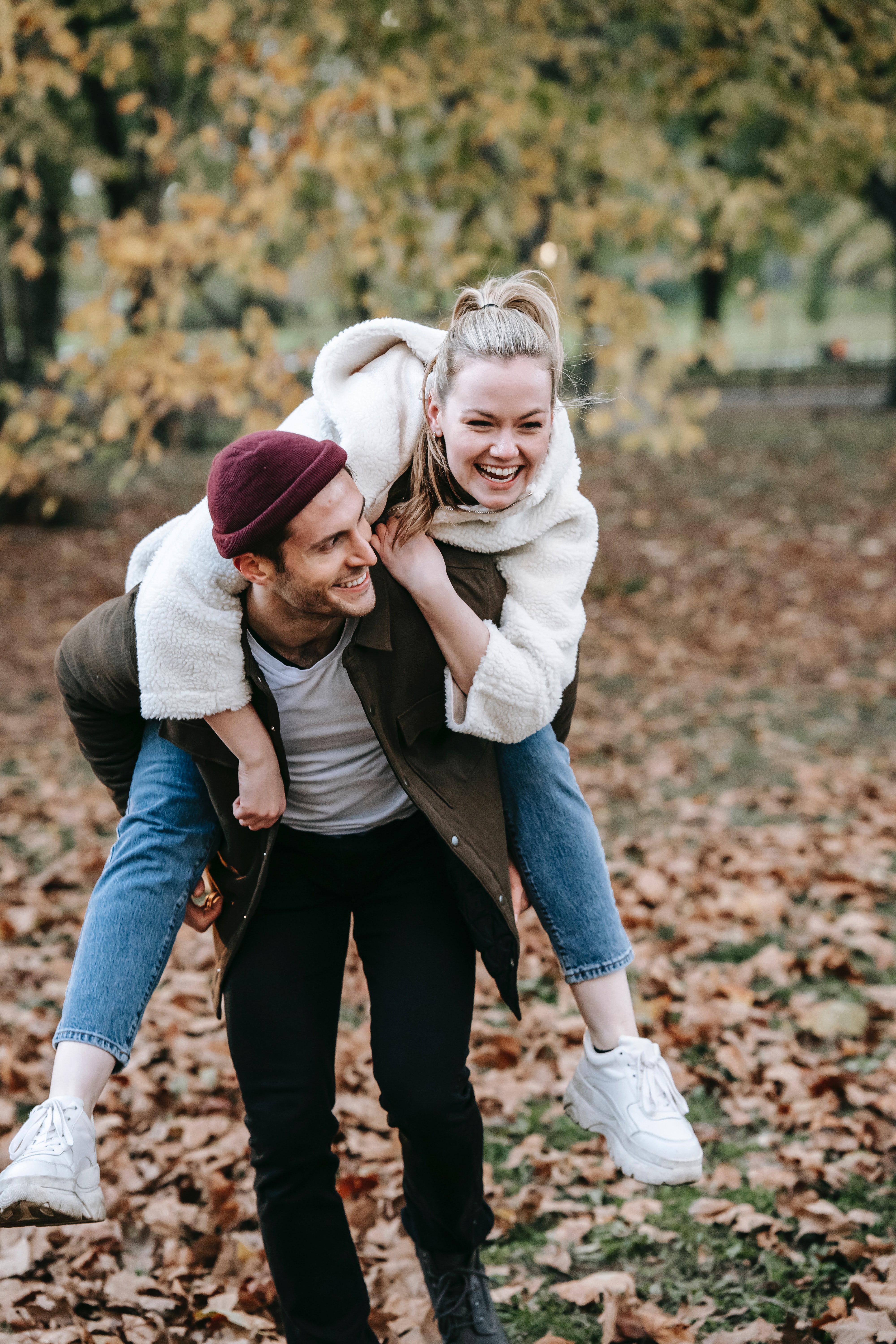 Couple enjoying piggyback ride in park · Free