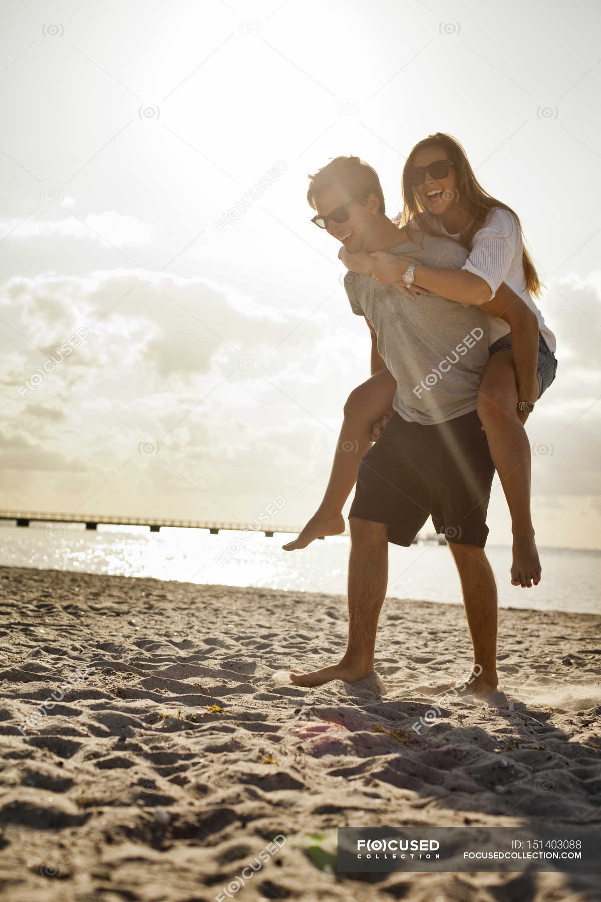 Couple enjoying piggyback ride at beach