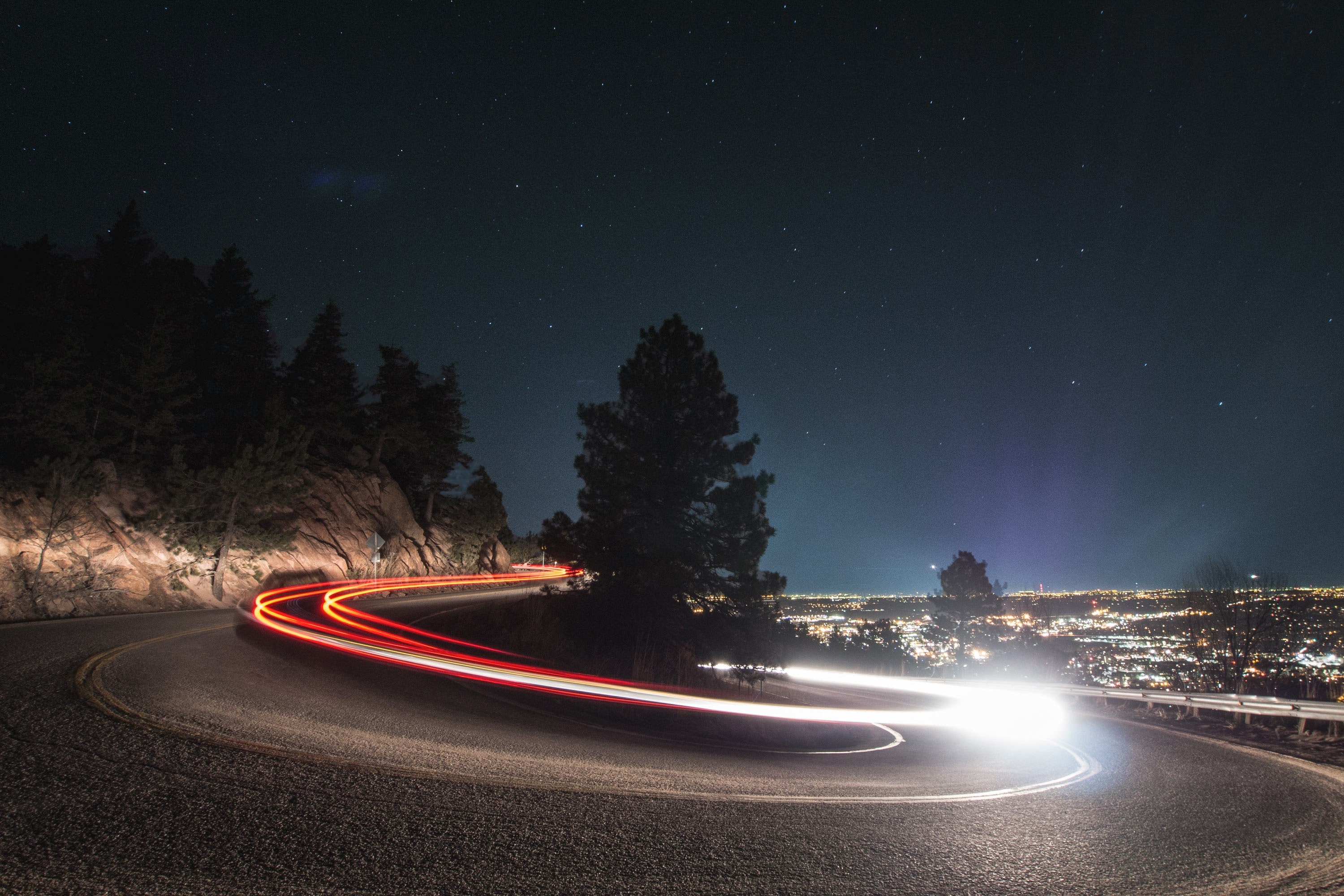 Wallpaper / a slow shutter shot of a curved road in boulder with fast driving car light trails, tokyo drift 4k wallpaper free download