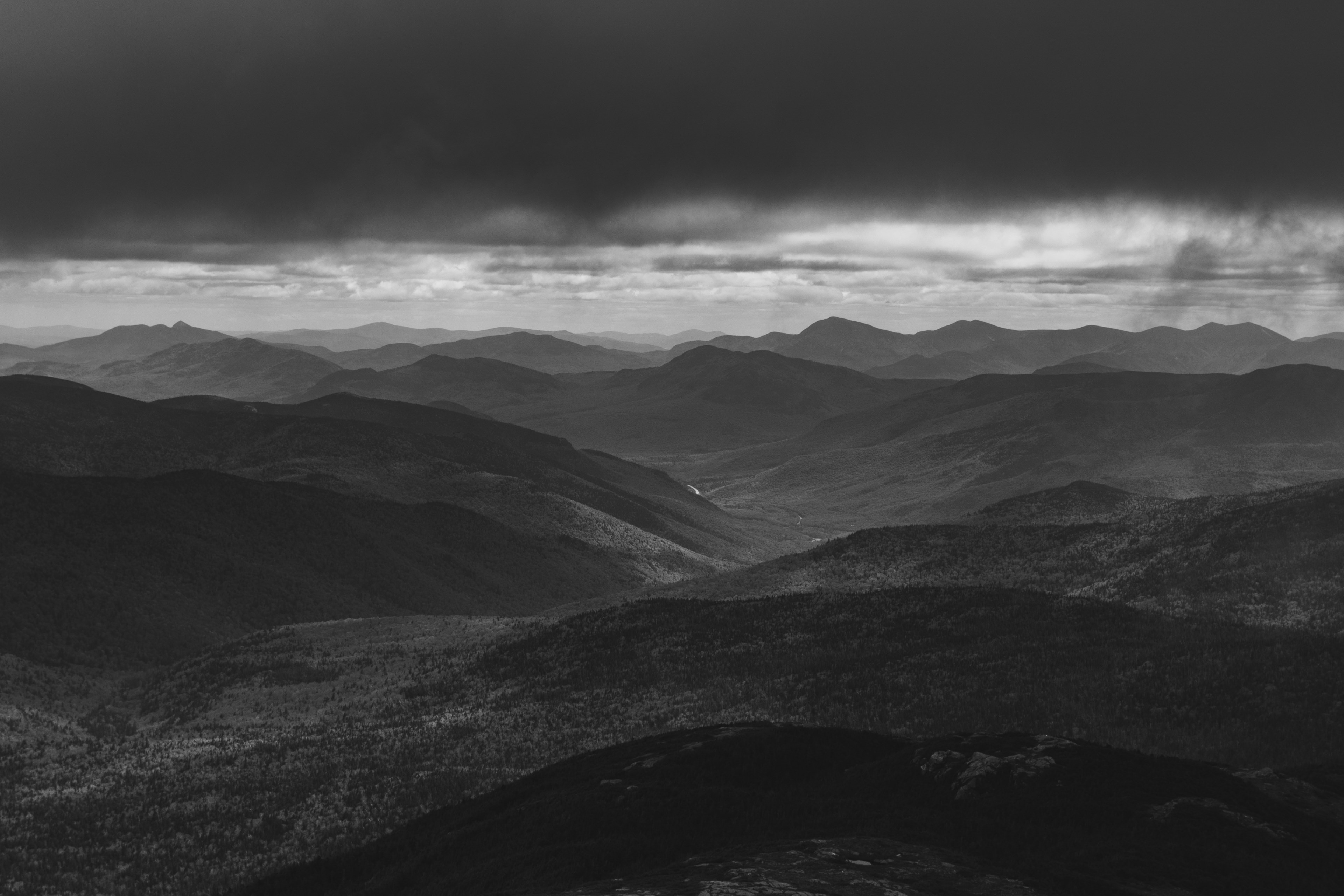 Wallpaper / an desaturated shot of a hilly landscape under thick clouds, ominous highlands 4k wallpaper