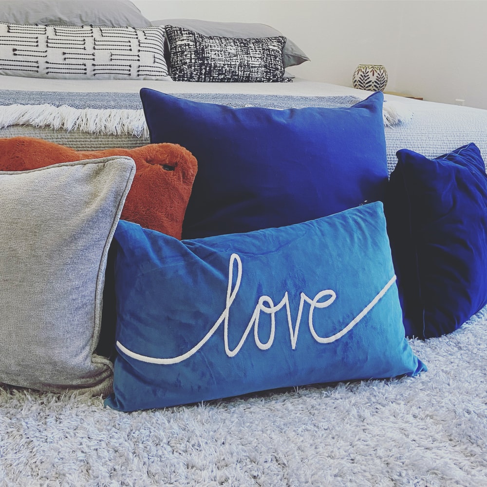 blue and white throw pillows on gray couch photo