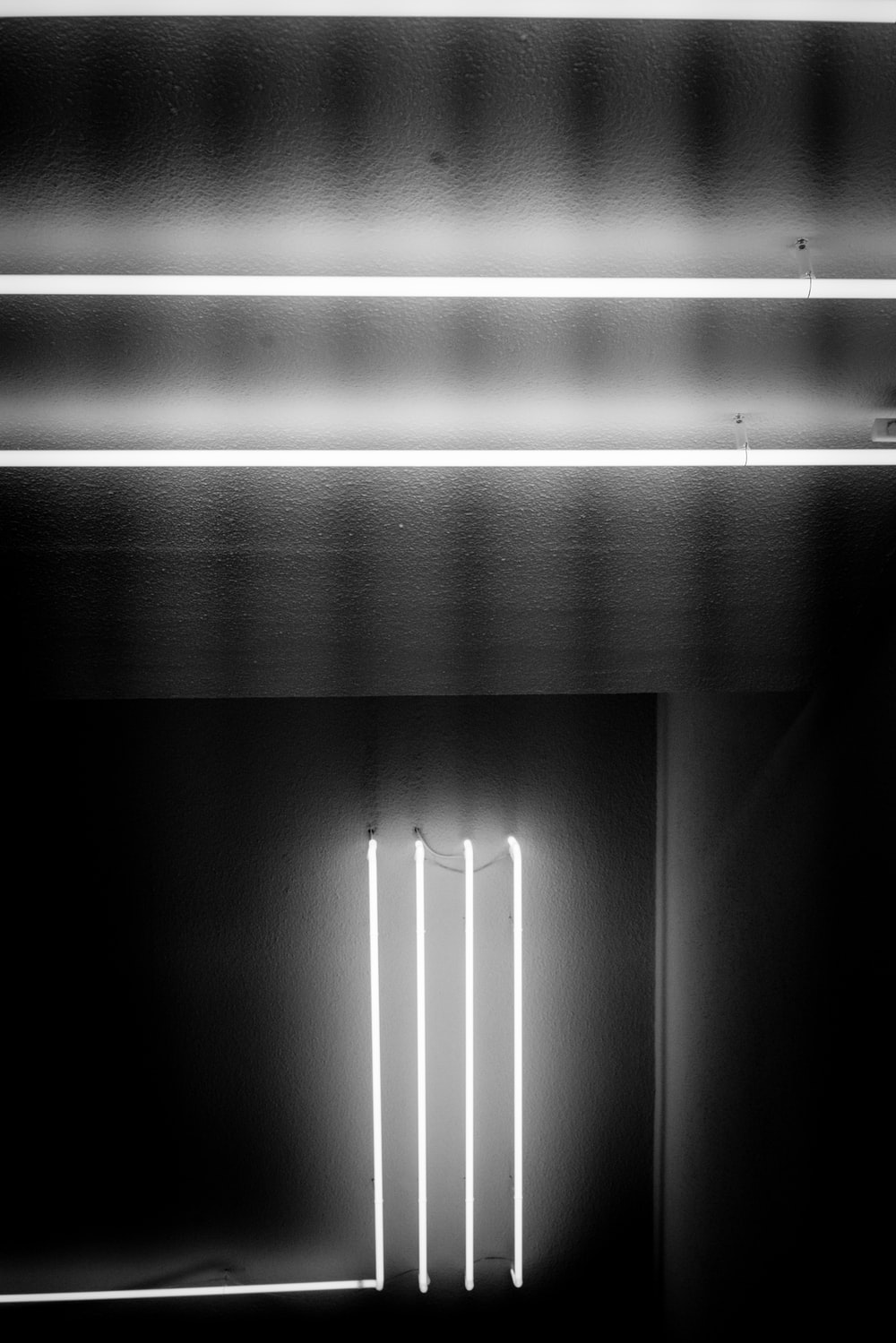 greyscale photography of lighted fluorescent lamps inside room photo