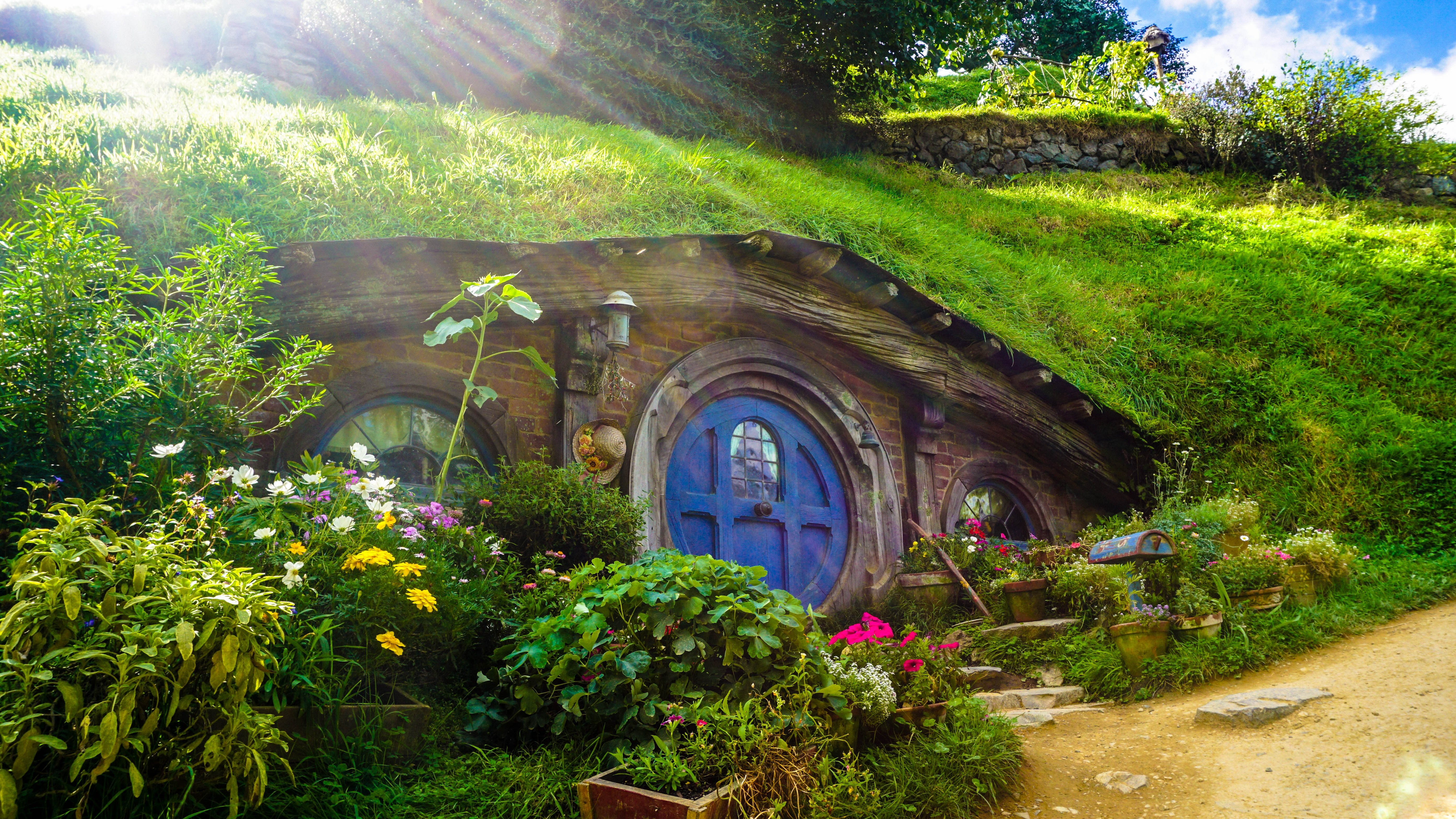 5575x3137 #blue door, #house, #shire, #structure, #green, #countryside, #hobbit, #movie set, #cottage, #garden, #tree, #hobbit hole, # hobbit house, #sunlight, #lord of the ring, #garden house, #window, #grass, #architecture, #Creative Commons