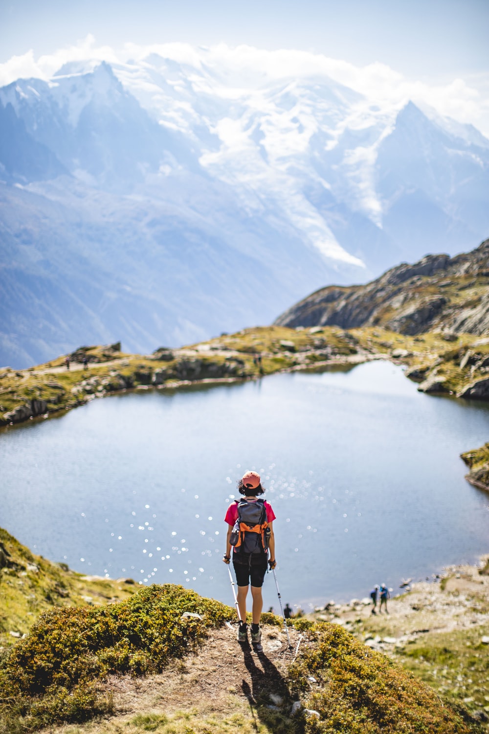 Man In Blue T Shirt And Black Shorts With Hiking Backpack Walking On Rocky Mountain During Photo