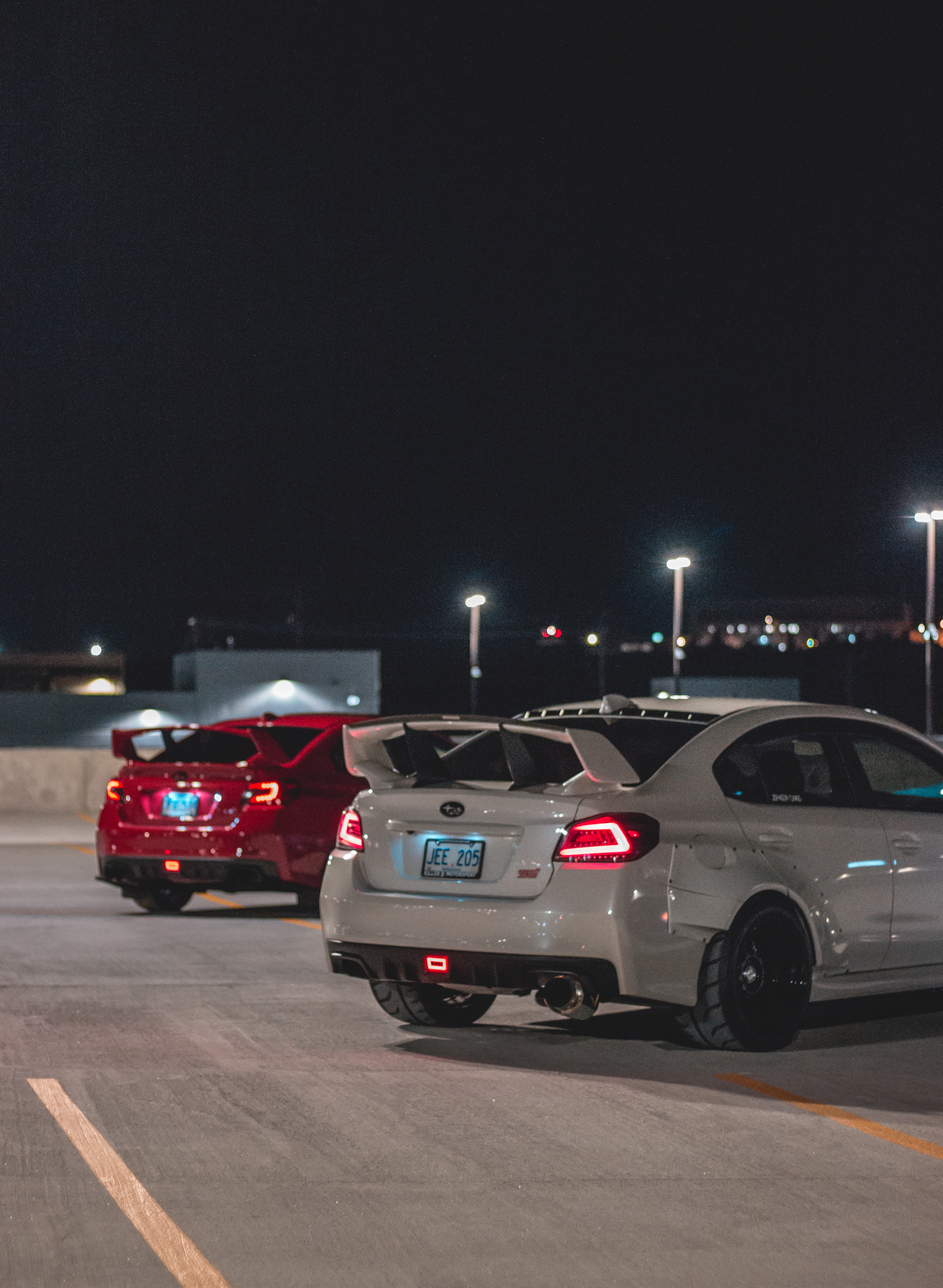 Modern cars with spoilers on parking at night · Free