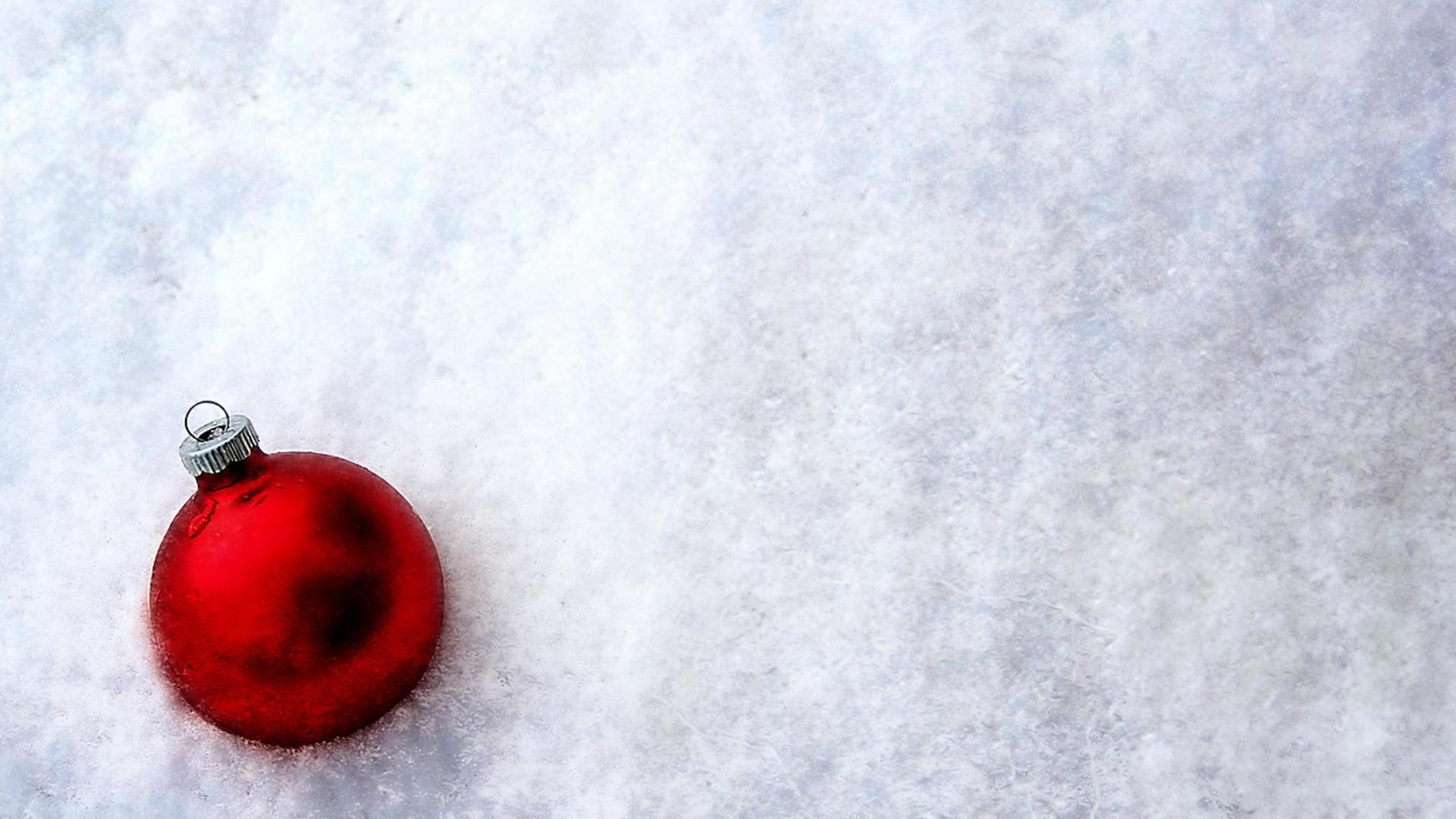 Shiny red Christmas ball in the white and cold snow