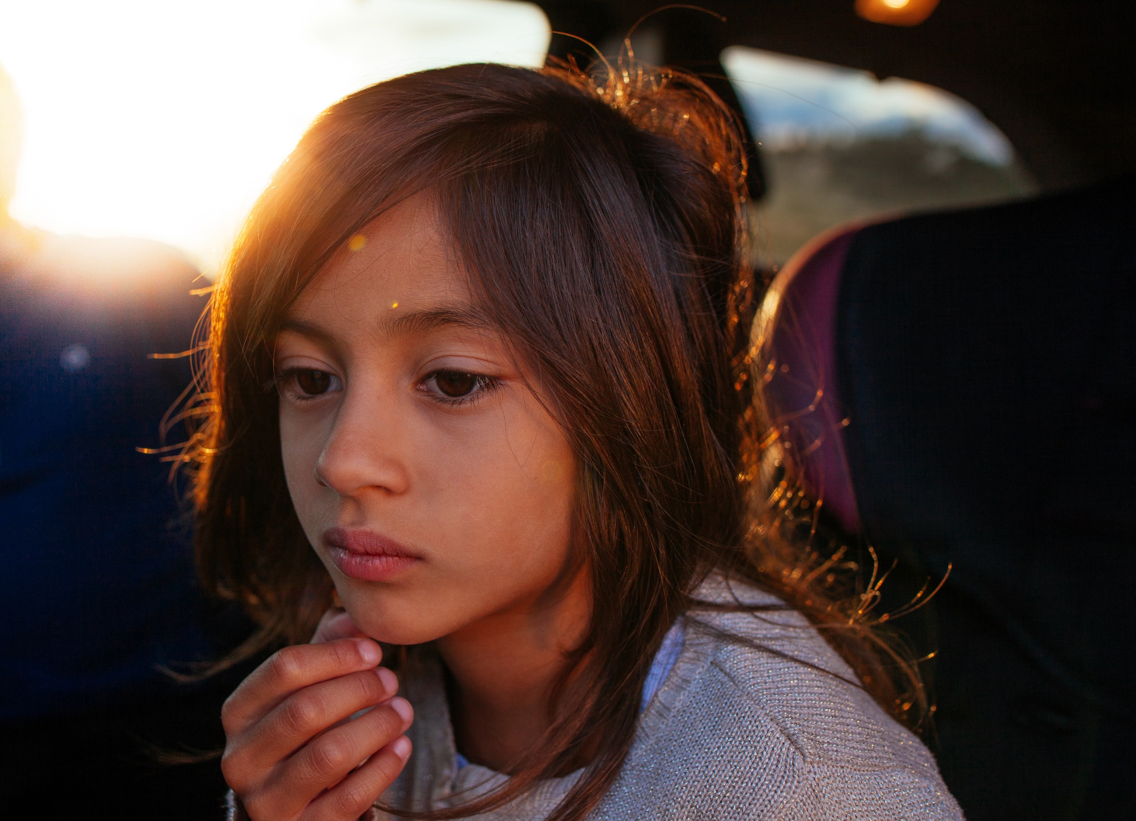 Wallpaper / sad young child sitting in a car alone, lonely road trip 4k wallpaper
