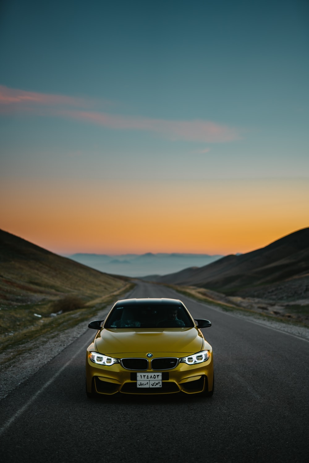 yellow BMW car on road photo