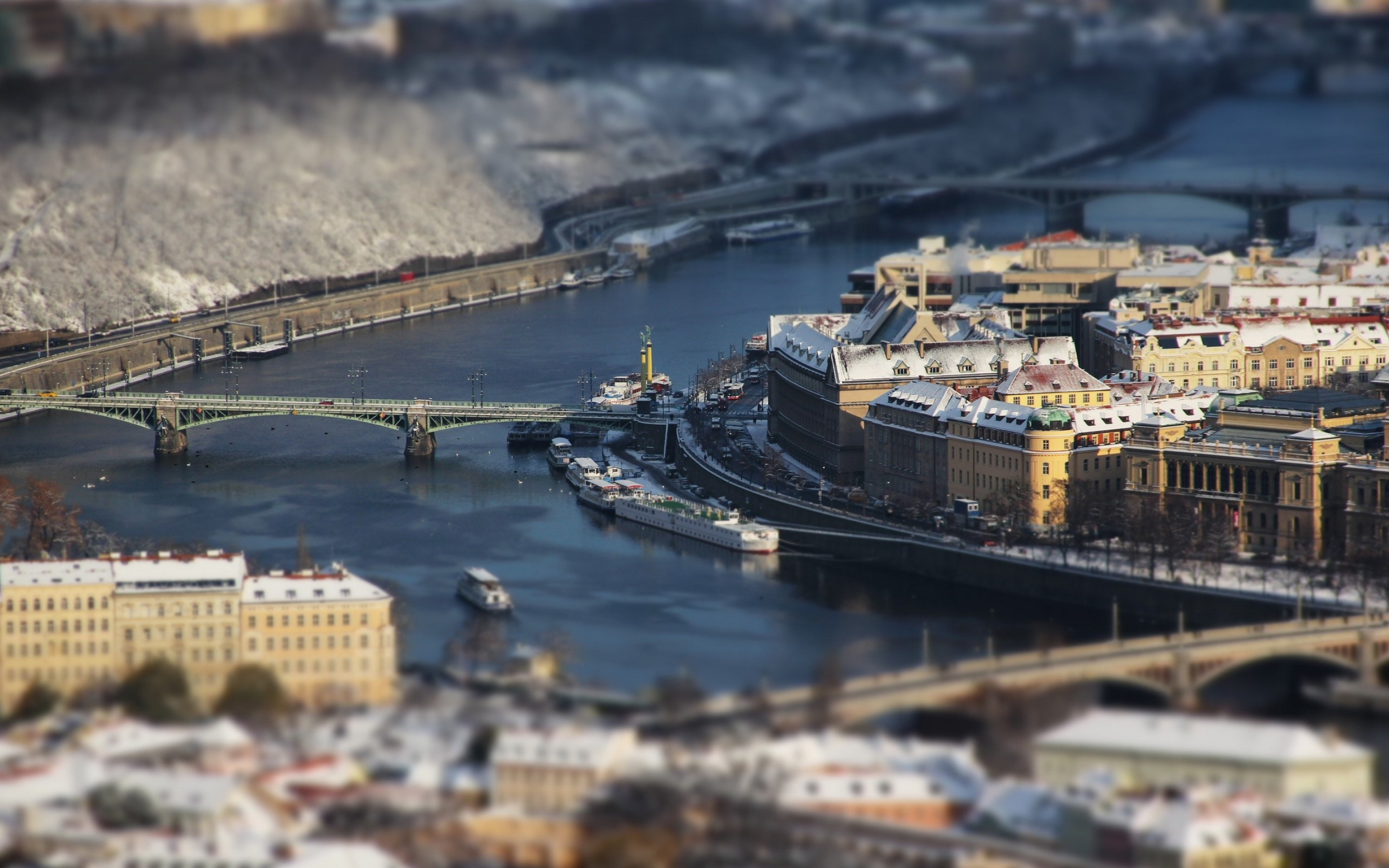 Download 2880x1800 Prague, Czech Republic, Tilt Shift, Photography, River, Bridges, Buildings Wallpaper For MacBook Pro 15 Inch