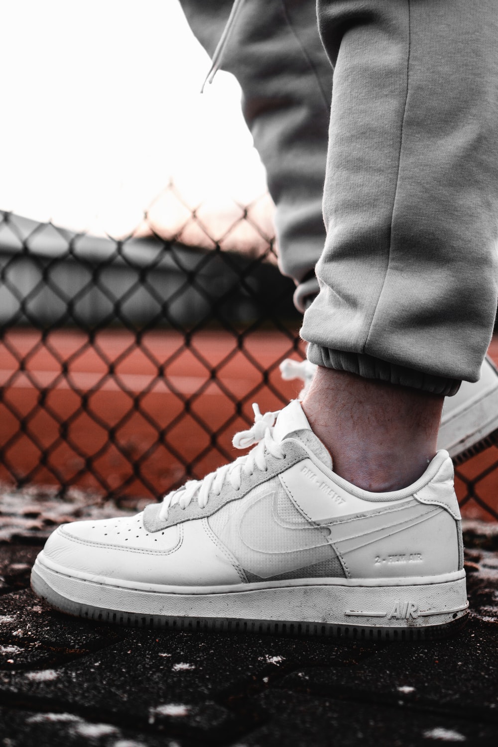 person in gray pants wearing white nike air force 1 low photo – Free Baden
