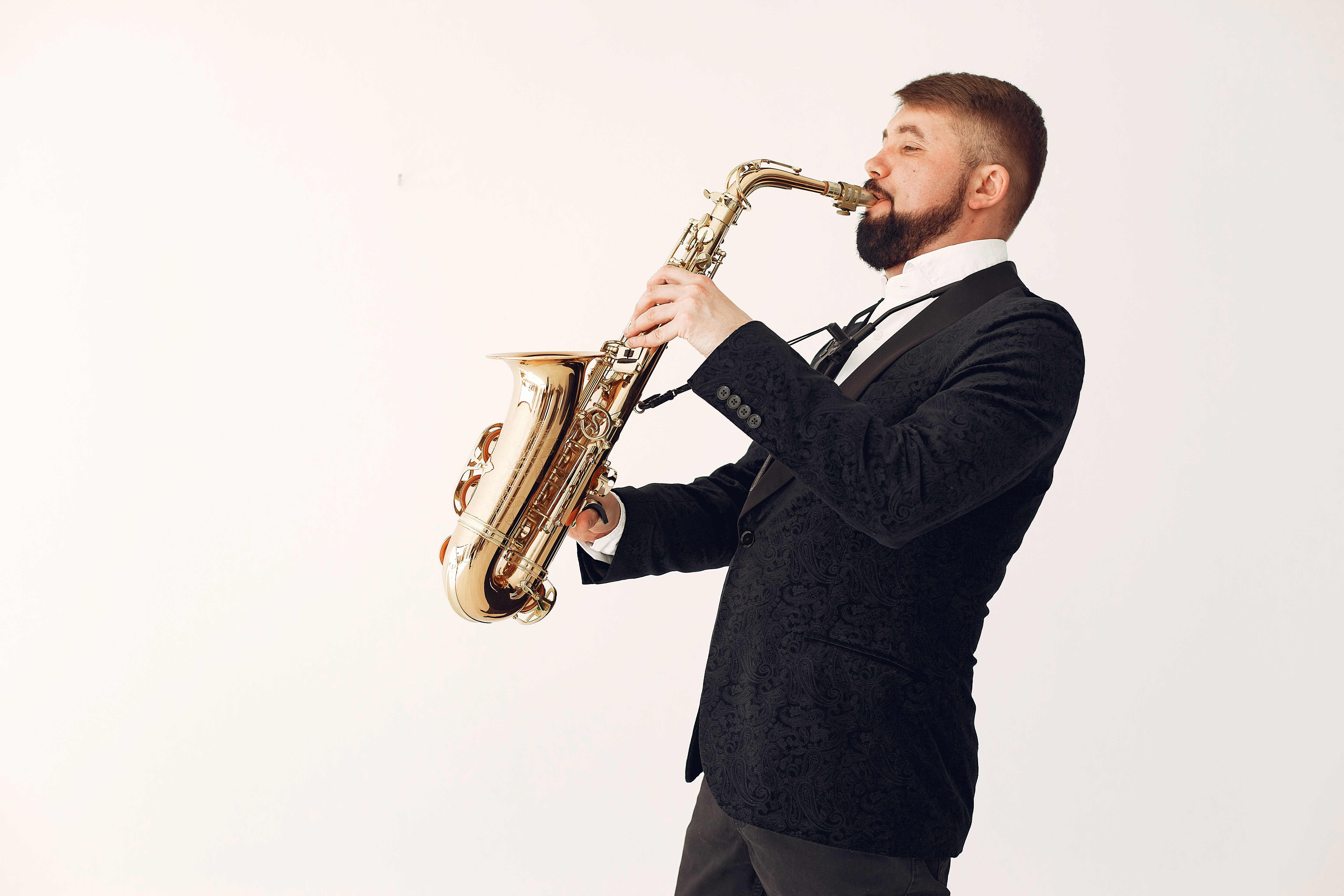 Adult man playing saxophone during rehearsal isolated on white background · Free