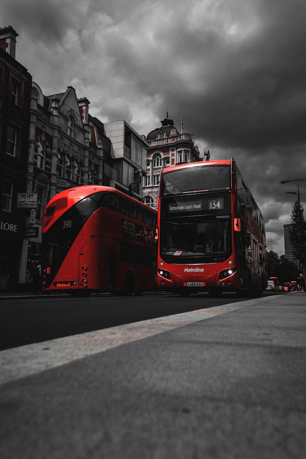 red and black bus on road near concrete buildings photo