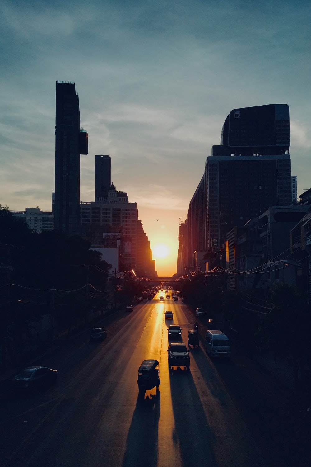 cars on road between high rise buildings during sunset photo