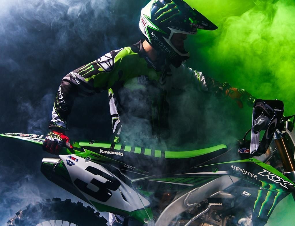 Download A Green Kawasaki Motocross Bike On A Black Background Wallpaper   Wallpaperscom