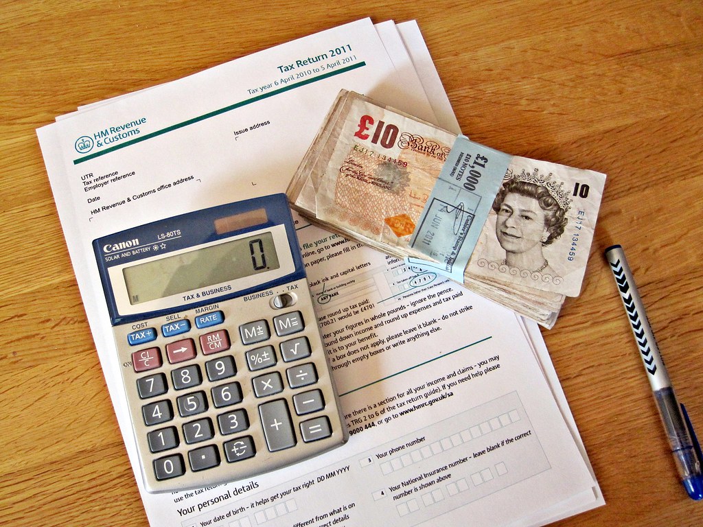 Income Tax Return. A calculator, wad of cash, pen and a tax